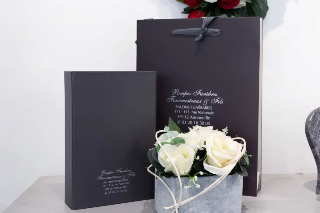 Sac et pochette funéraires Fourmestraux avec un bouquet de roses blanches.