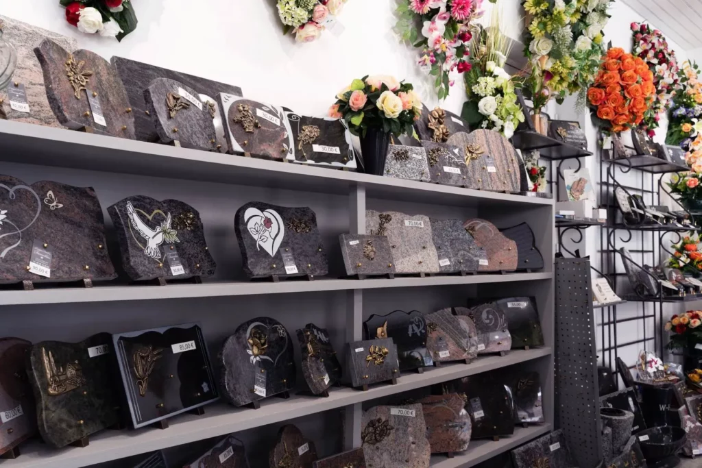 Magasin d'articles funéraires avec plaques en marbre et compositions florales.